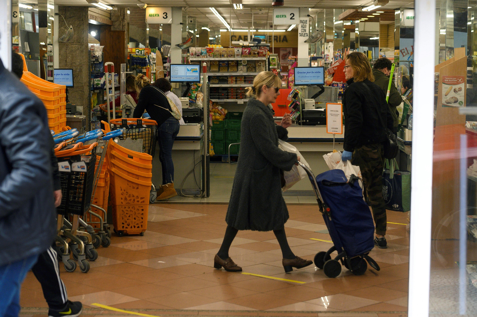 Varias personas realizan sus compras en un supermercado