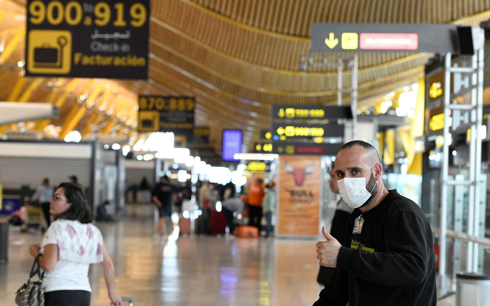 Pasajeros se protegen con mascarillas en la terminal 4 del aeropuerto Adolfo Suarez Madrid Barajas. EFE/ Víctor Lerena