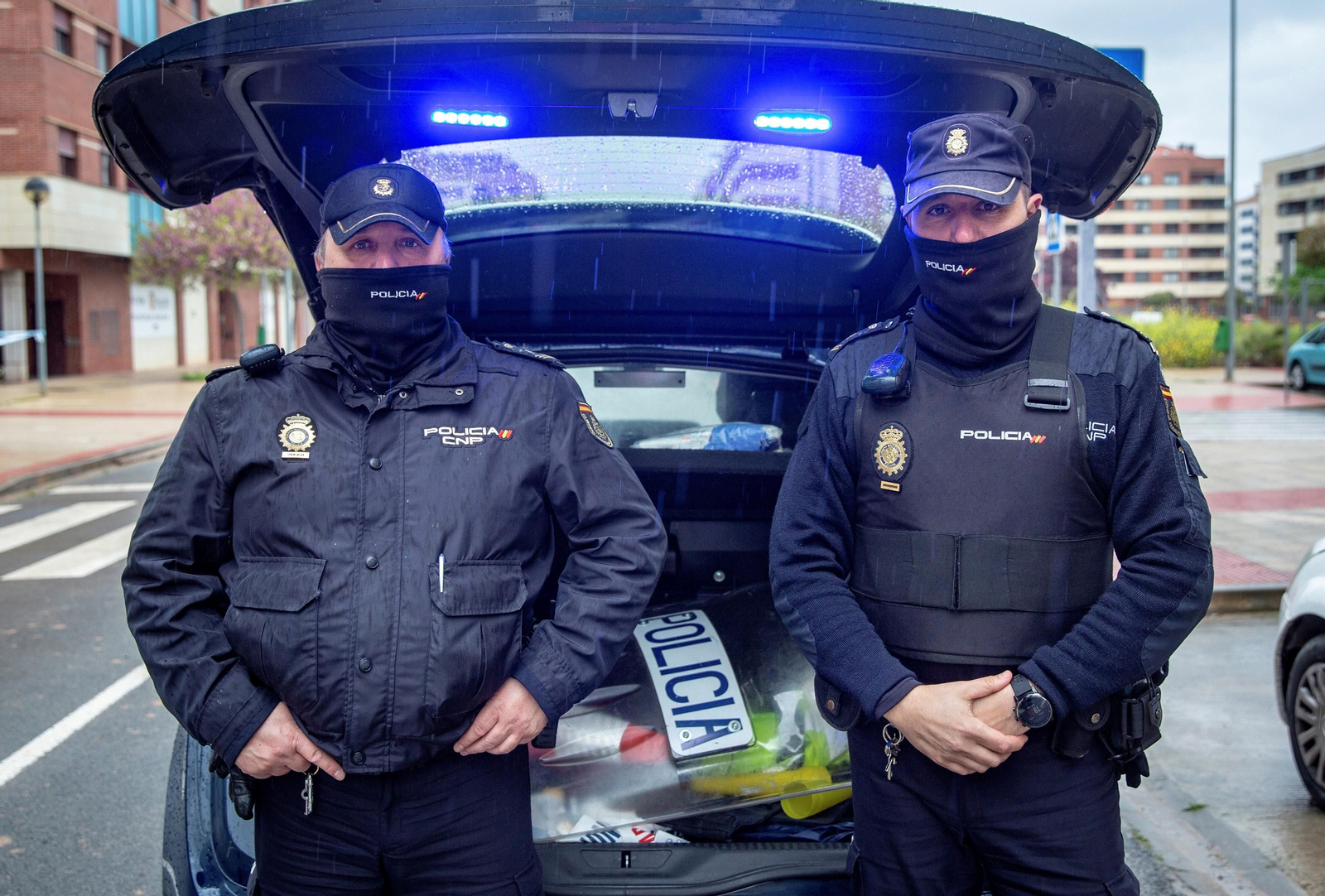 Los agentes Miguel (i) y Juanan (d), de la Brigada de Seguridad Ciudadana de la Jefatura Superior de Policía de La Rioja, posan junto a su coche patrulla en Logroño.