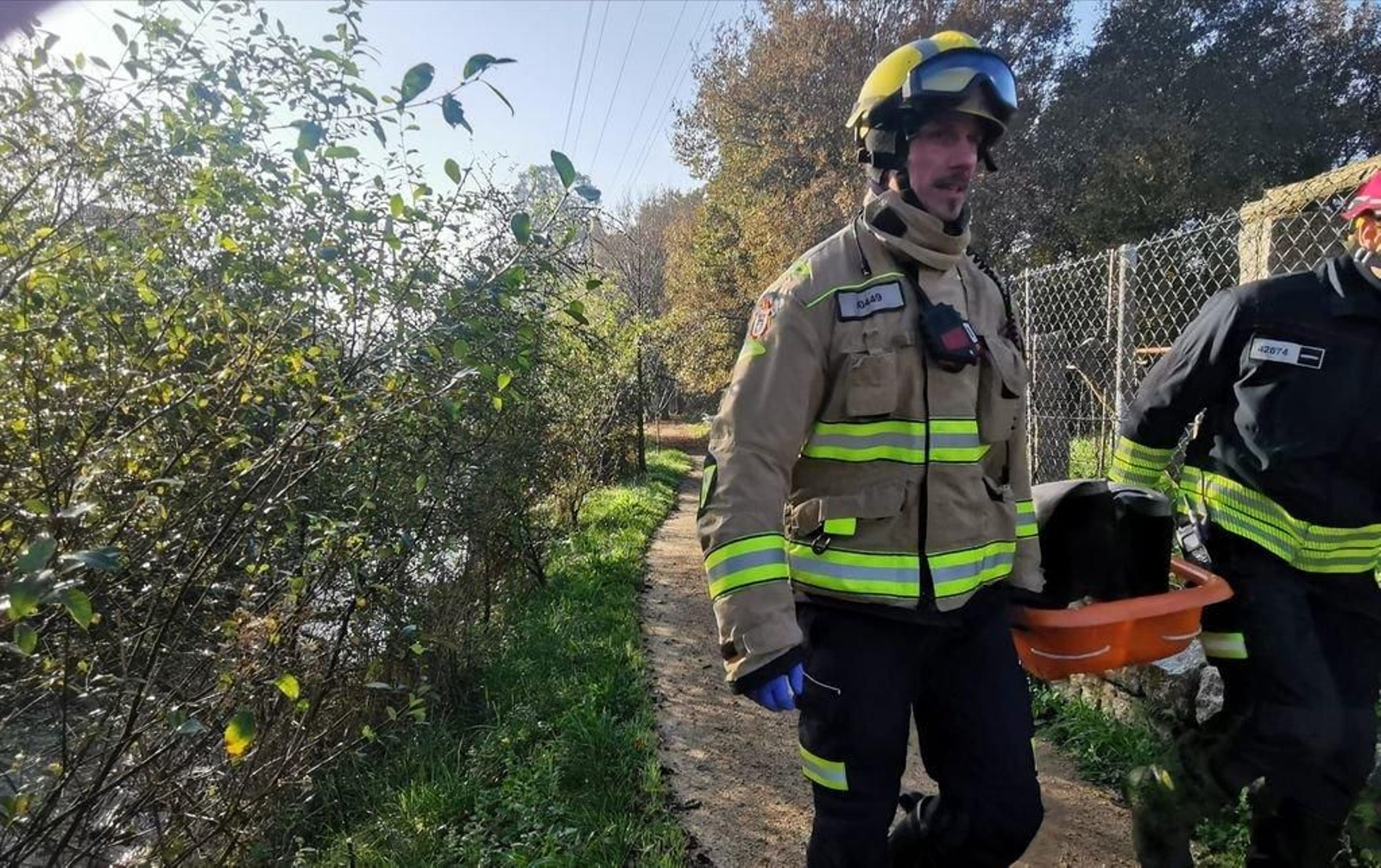 Los bomberos con la camilla para transportar el cadáver.