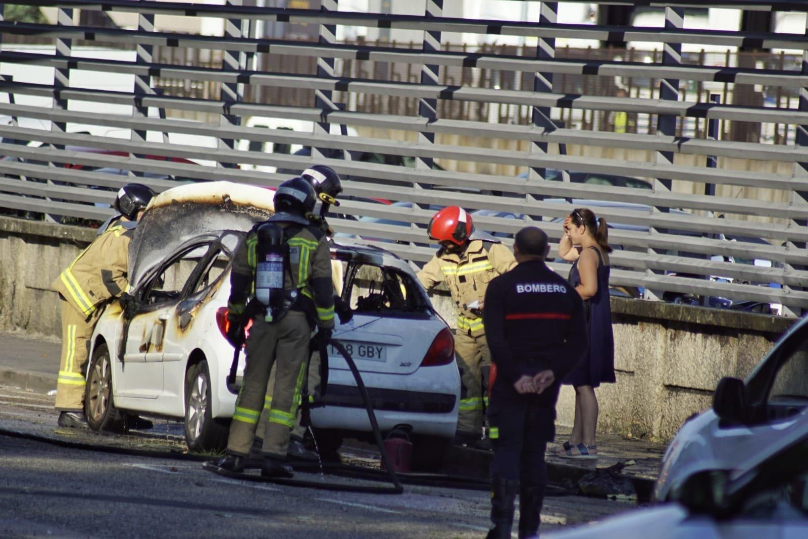 Los bomberos tras sofocar el incendio del vehículo // Vicente Alonso
