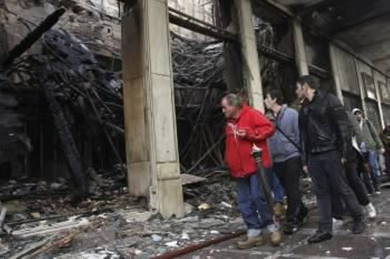 Atenienses observan los daños causados en la ciudad tras los altercados (Foto: ORESTIS PANAGIOTOU)