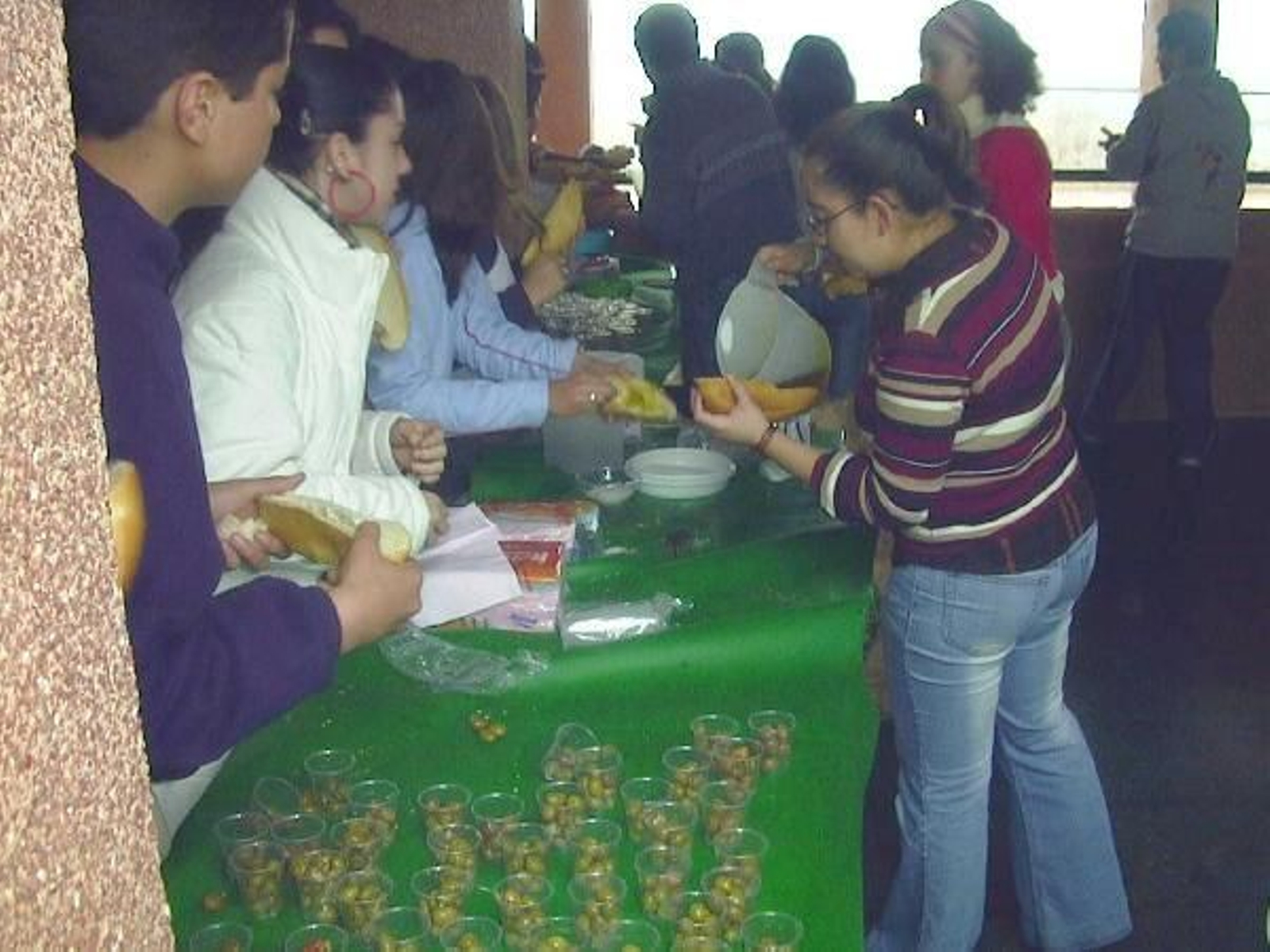 Varios niños realizan un 'desayuno molinero' a base de pan y aceite de oliva.