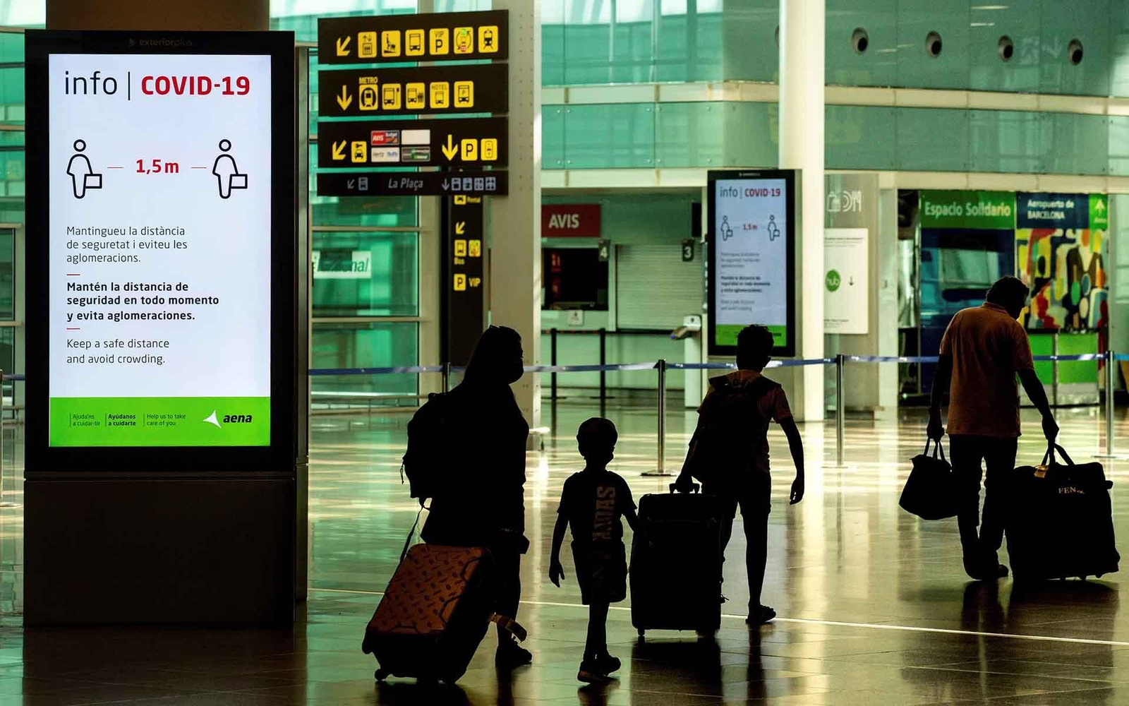 Viajeros con máscaras sanitarias caminan  por la Terminal 1 del aeropuerto Josep Tarradelles - El Prat, en Barcelona. EFE/ Enric Fontcuberta