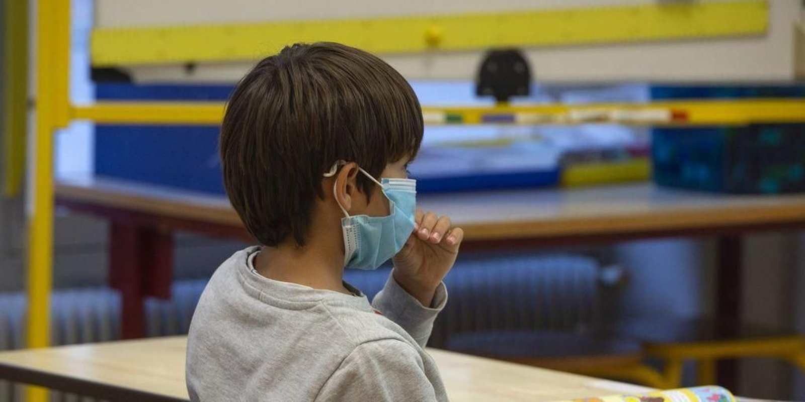 Un niño protegido con una mascarilla, en un aula.