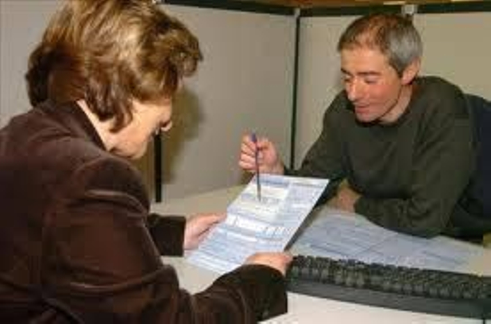 Un funcionario aclara las dudas de una ciudadana en ventanilla.