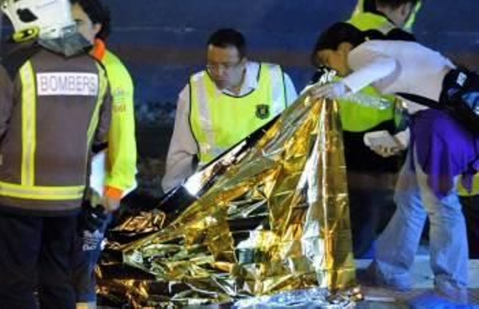 Miembros de la policía y de los equipos de rescate inspeccionan uno de los cadáveres de la tragedia de Castelldefells