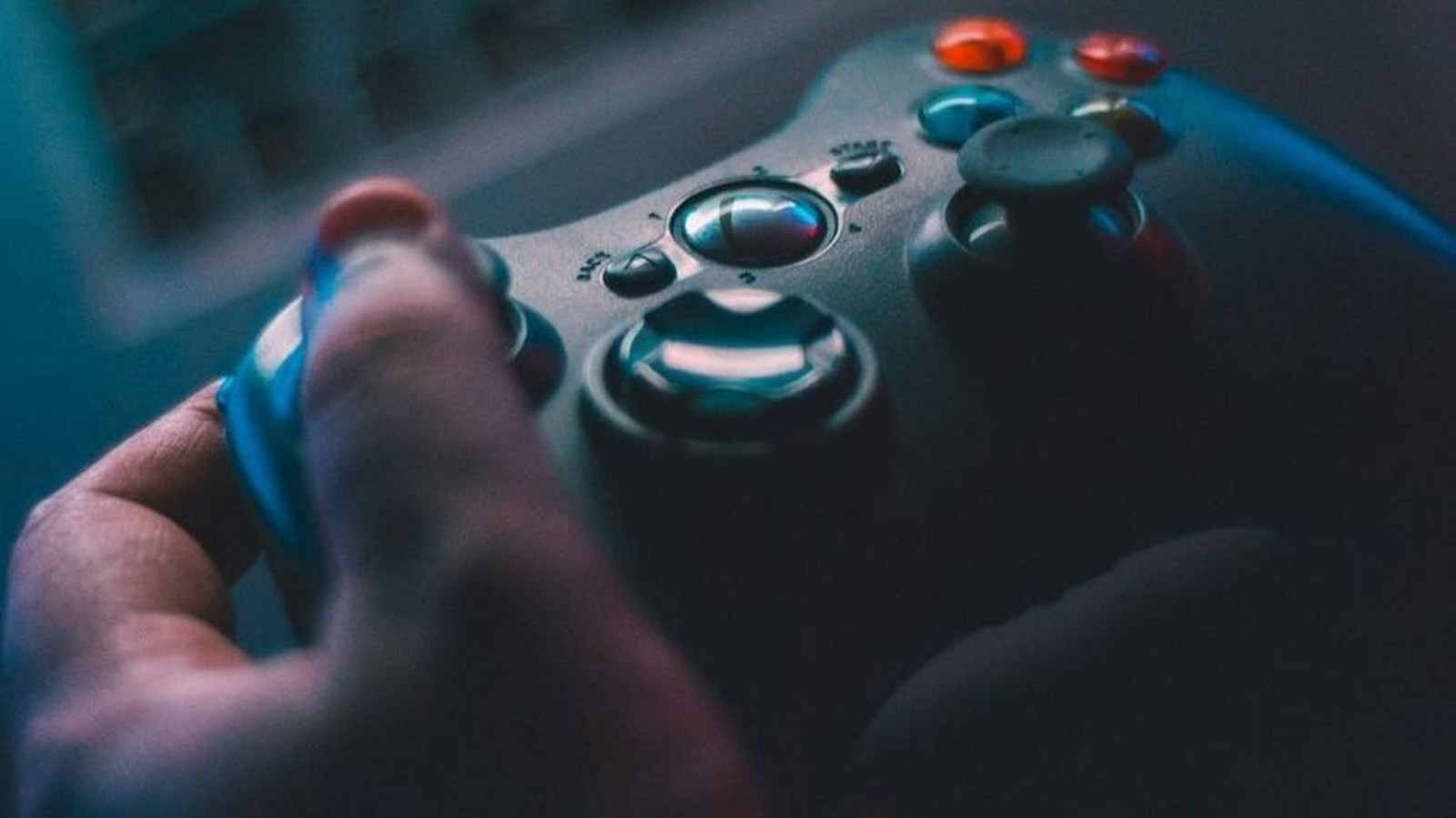 Un joven utiliza el mando de una videoconsola Xbox mientras juega.