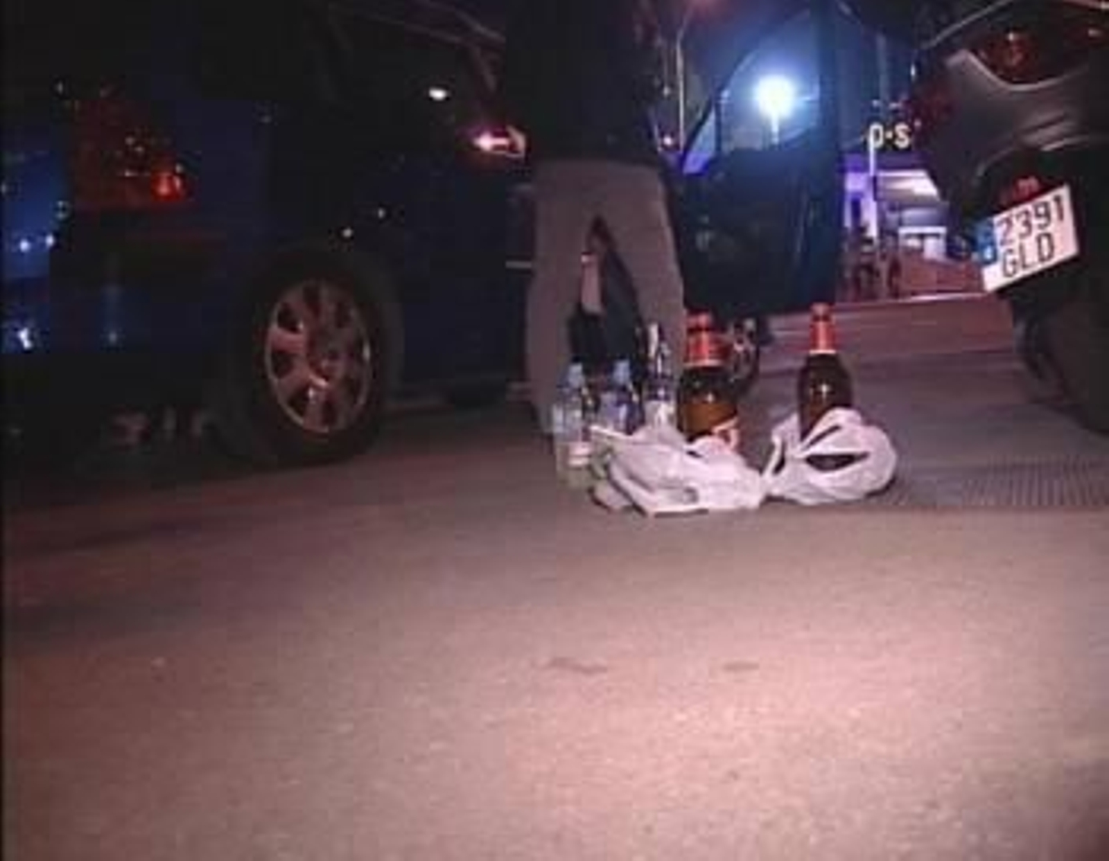 Un joven, junto a varias botellas de alcohol.