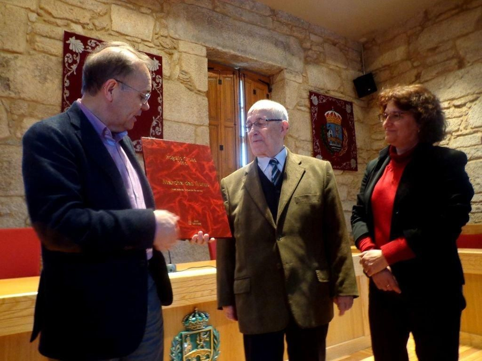 Represas recogiendo de manos de Rogelio Groba la partitura de 'A Marcha do Corpus'.