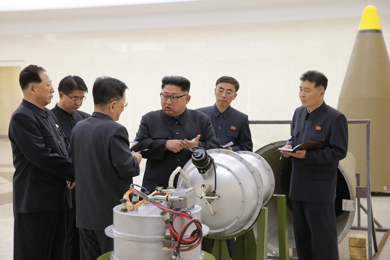 Kim Jong-un conversa con expertos ante una cabeza nuclear.