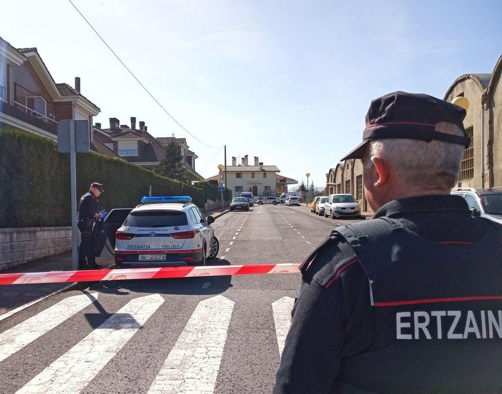 Dos ertzaintzas vigilan el domicilio donde se produjo un crimen machista.