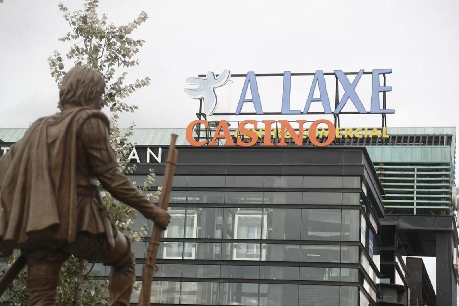 El Casino, en el centro comercial A Laxe, observado por la estatua de Gonzalo de Vigo.