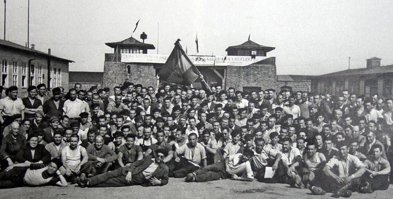 Los españoles presos en Mauthause, con la pancarta de bienvenida a las tropas aliadas, al fondo.