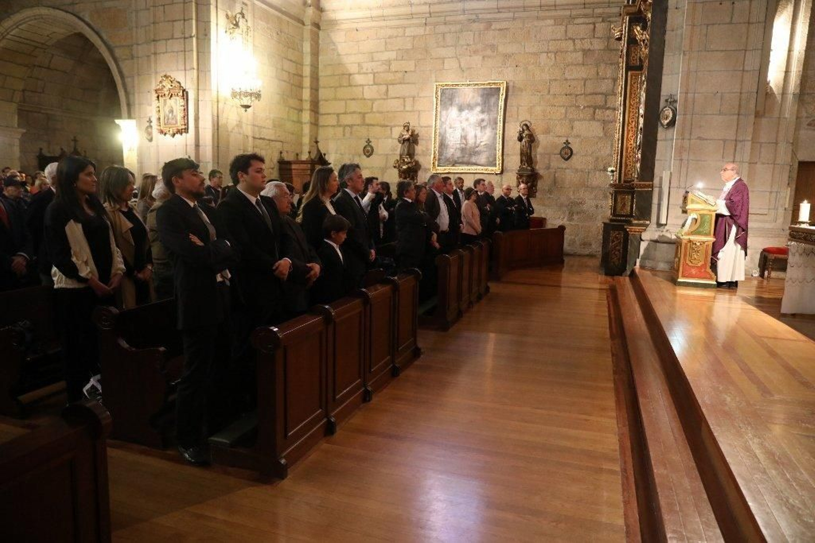 Los familiares escuchan las palabras del sacerdote durante la misa funeral.