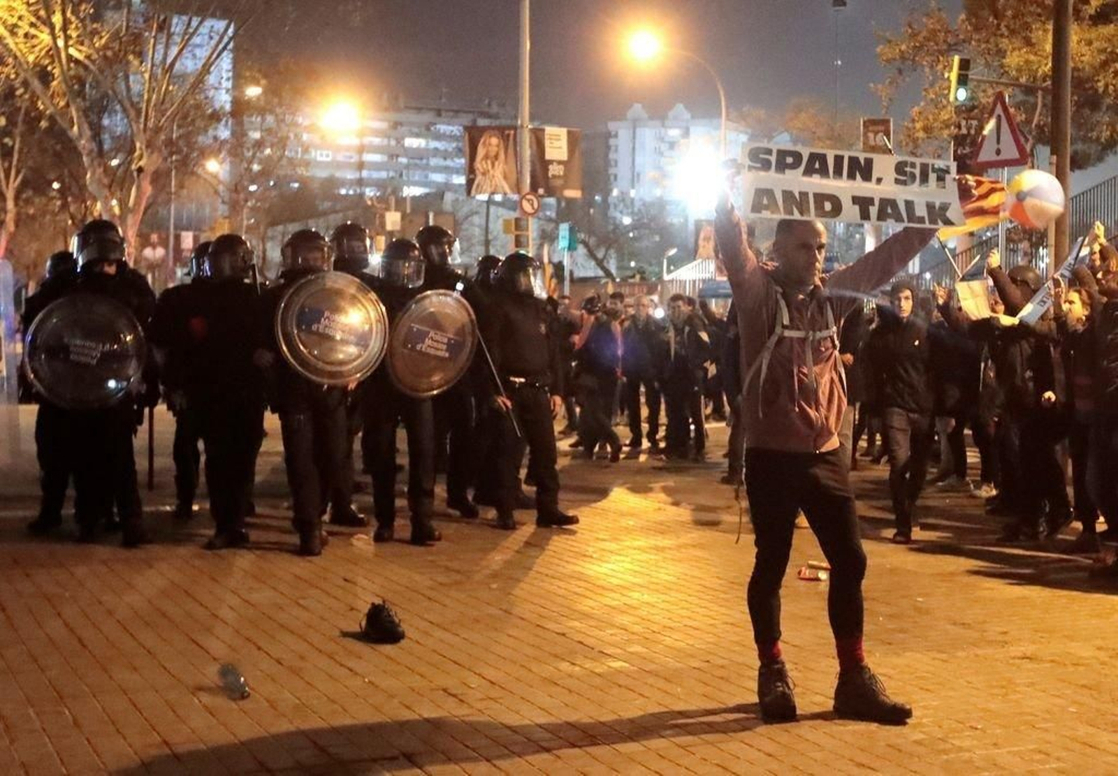 Un manifestante muestra el lema "España, siéntate y habla".