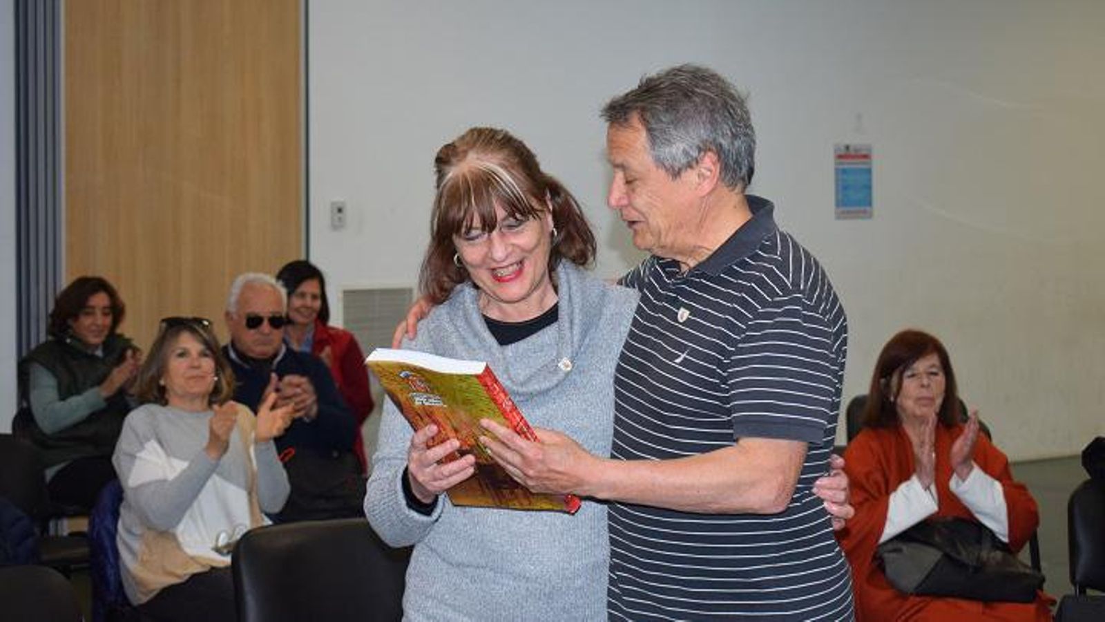 La presidenta del CRE de Bahía Blanca recibiendo un ejemplar del libro “100 años de Historia”