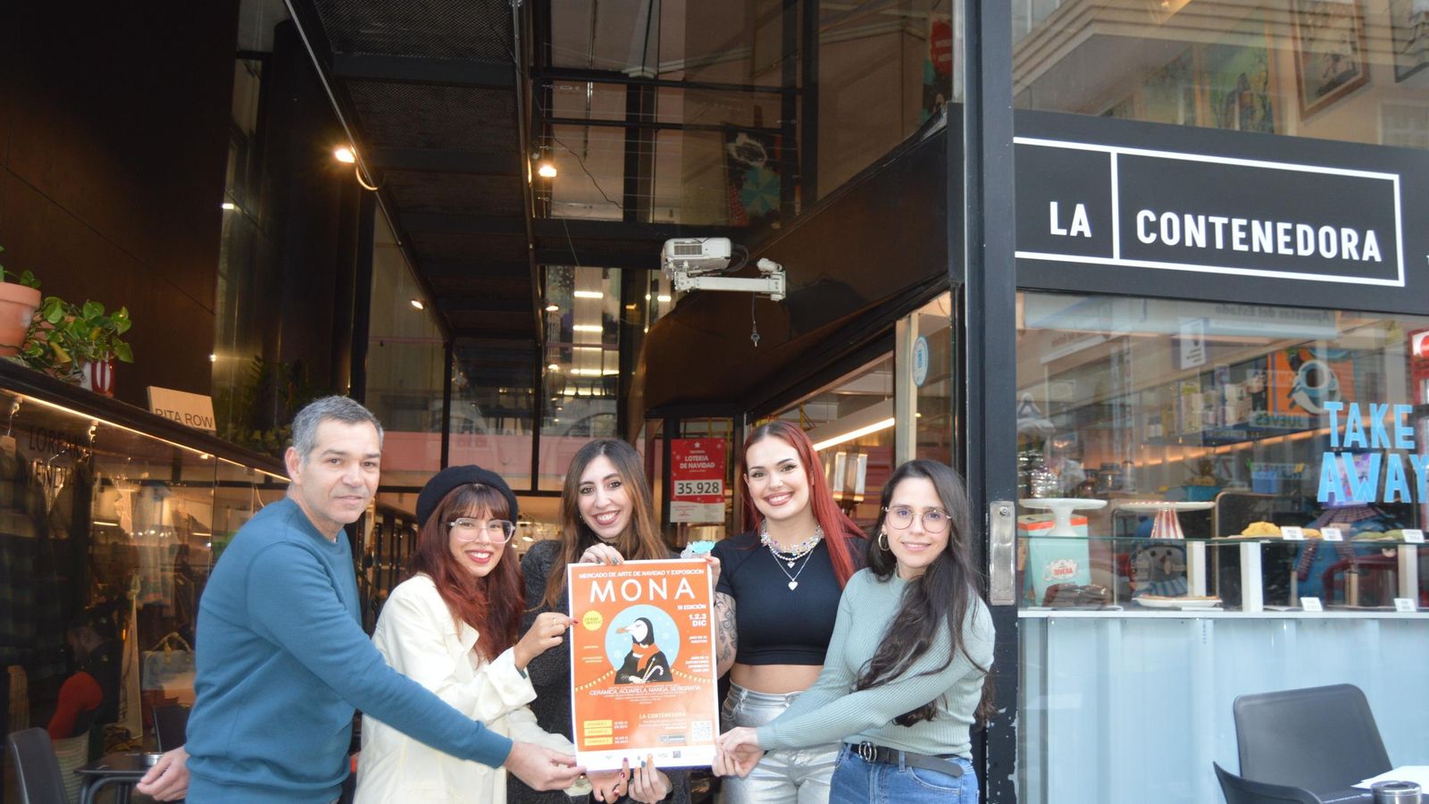 Algunos de los participantes de MONA, con el cartel de la tercera edición.
