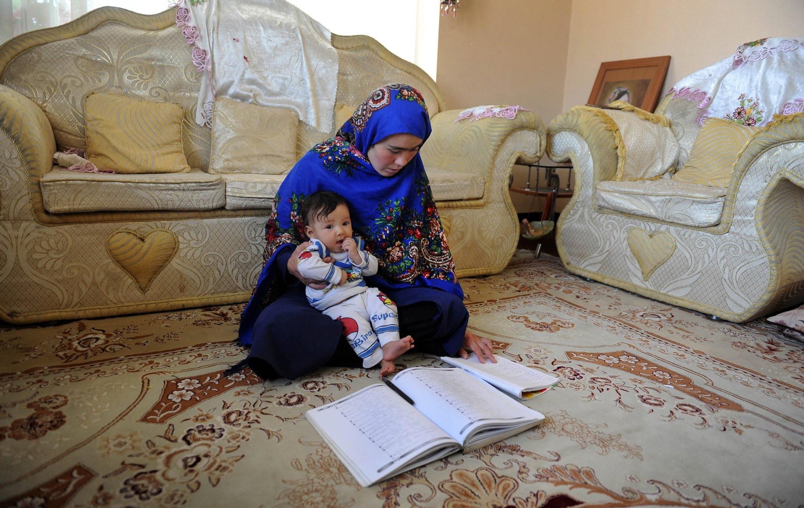 Jahantab Ahmadi, con uno de sus tres hijos en su casa mientras estudia.