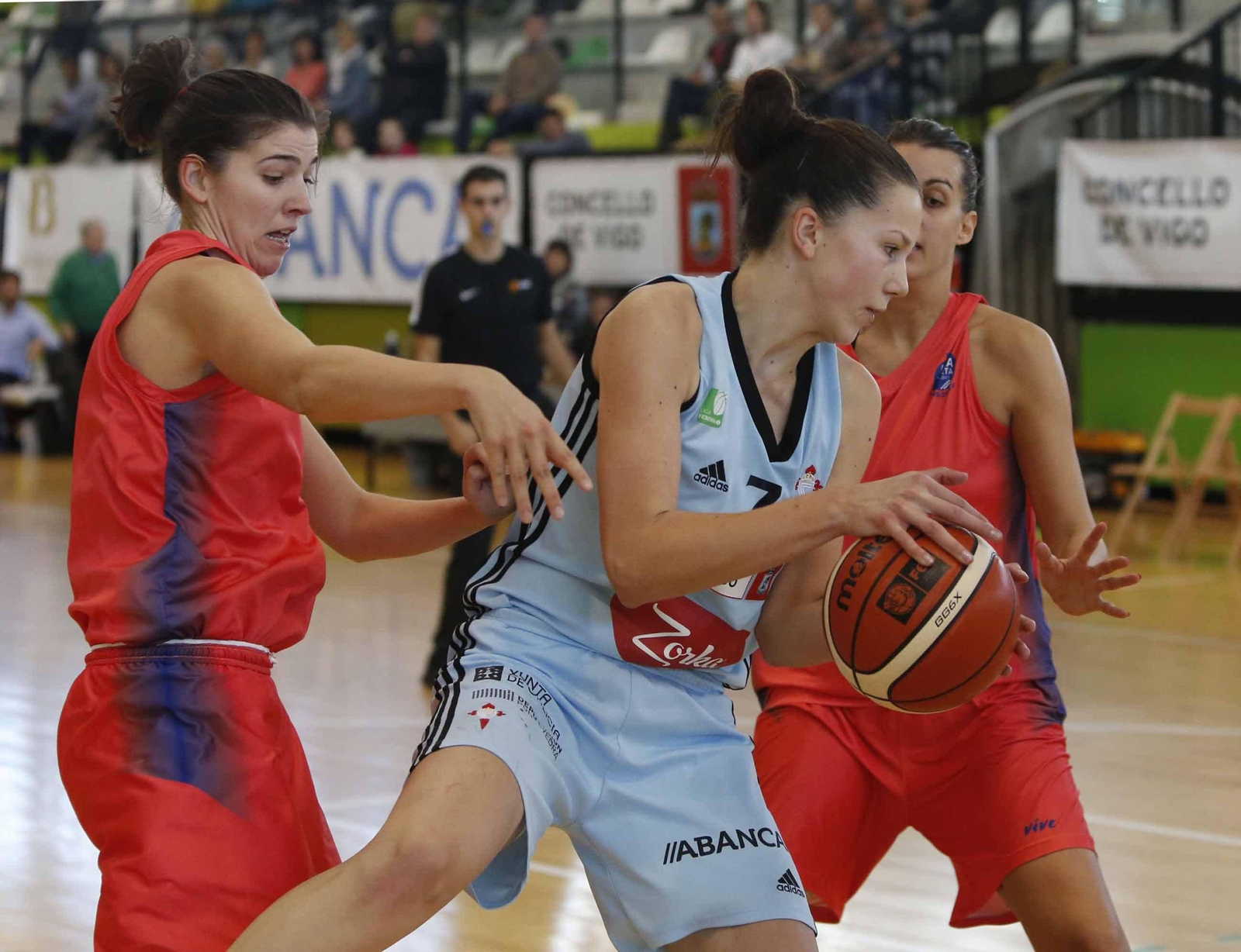Kristina Arsenic sostiene el balón entre dos oponentes en un partido anterior.