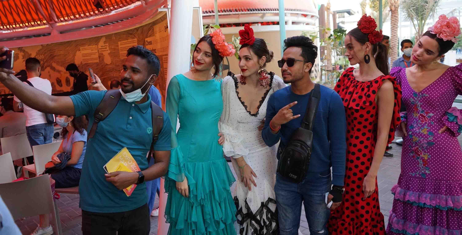 Unas jóvenes con trajes flamencos posan junto a los visitantes de la Expo Dubai, como parte de las iniciativas de la Semana de Andalucía en el pabellón de España en el recinto de la feria. EFE/Iñigo Álvarez