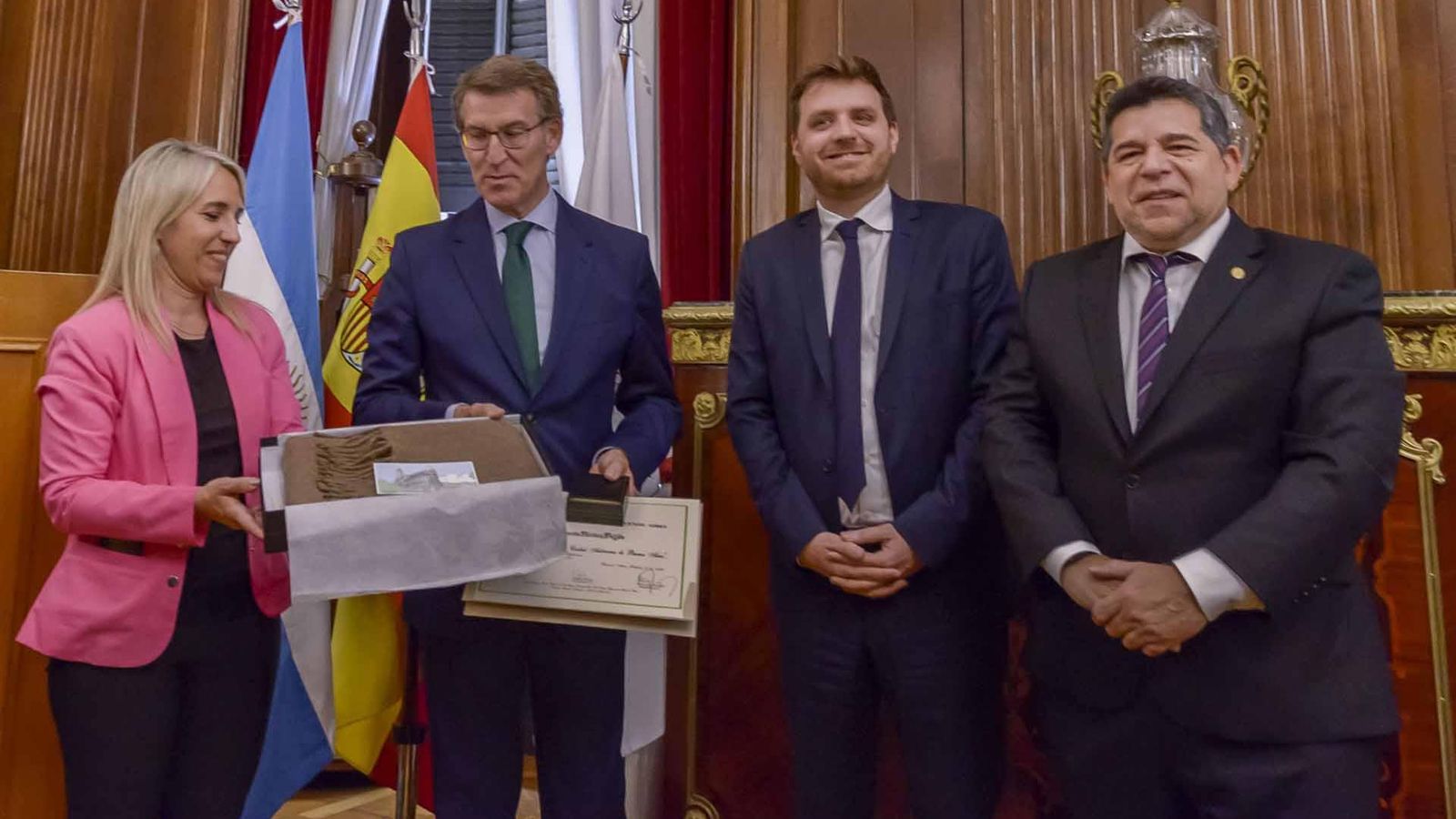 Feijóo recibiendo obsequios tradicionales que le entrega la diputada Cecilia Ferrero, acompañada del presidente de la Legislatura, Emmanuel Ferrario, y el diputado Romero  