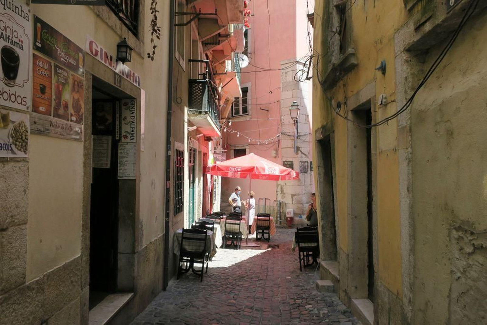 Poca gente por la calle y terrazas casi vacías en el popular barrio de Alfama de Lisboa.
