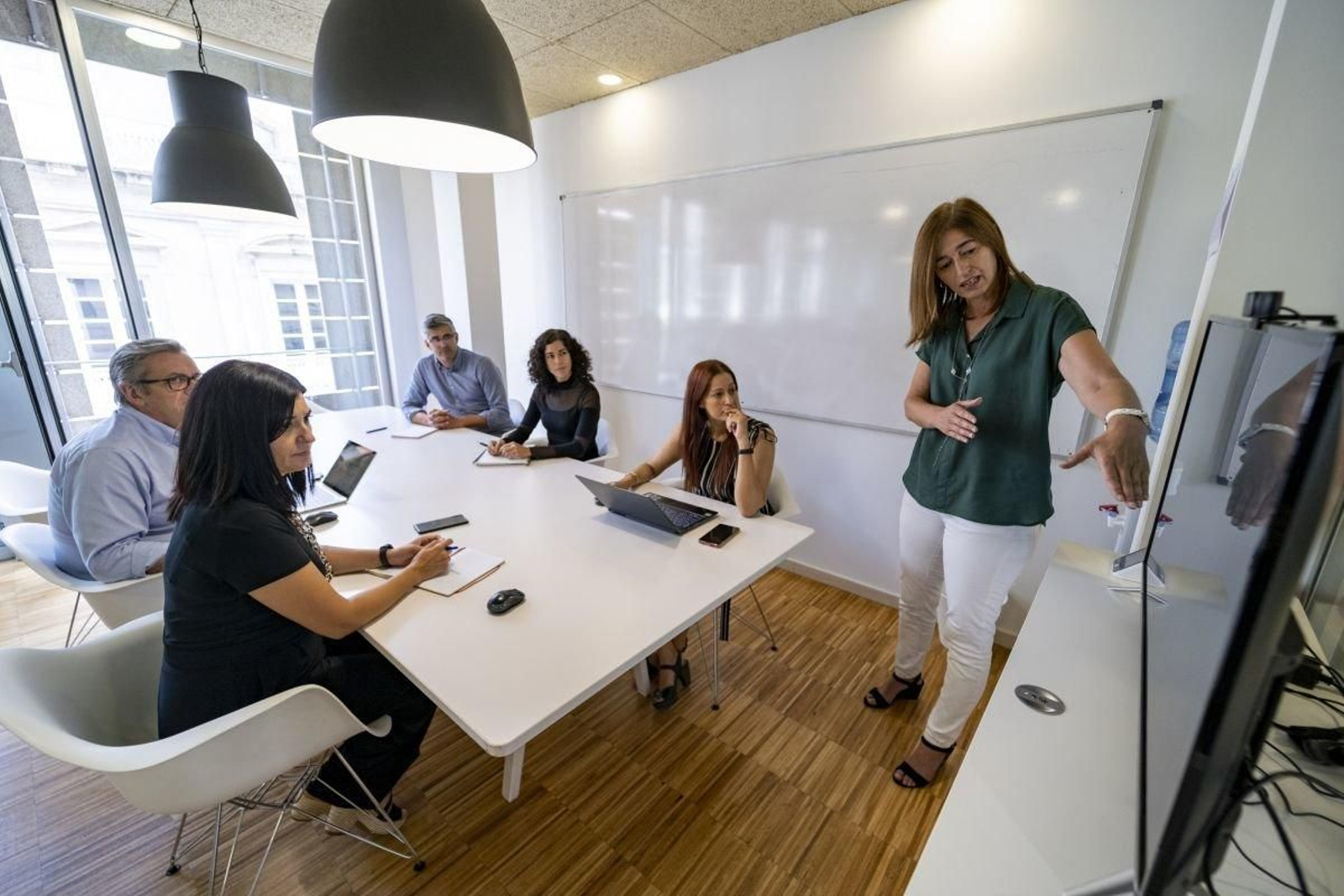 Equipo de Inova Labs en una reunión de trabajo, con Natalia Nogueira, directora de negocio, de pie.