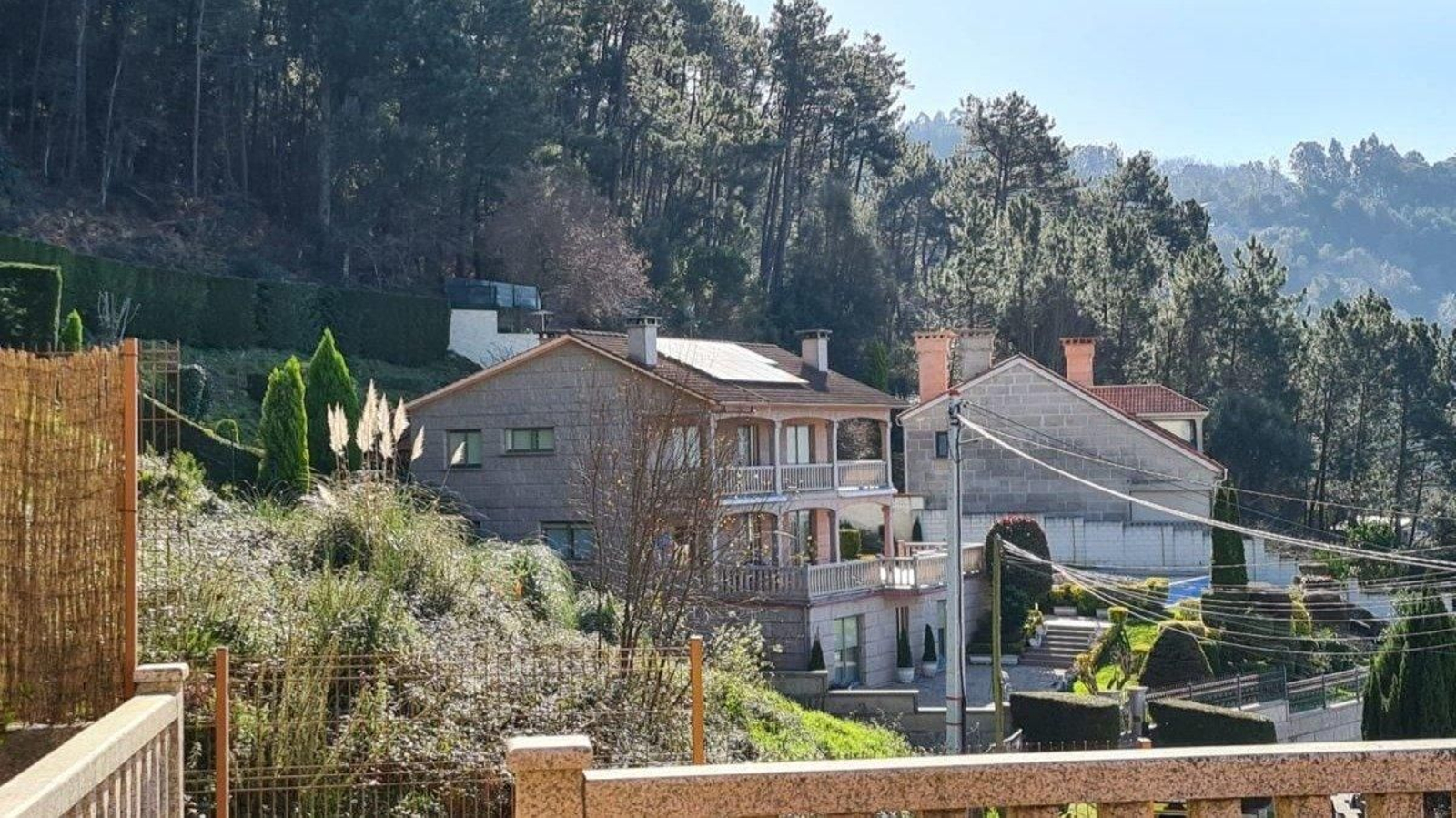 Imagen de dos viviendas pegadas a la masa forestal.