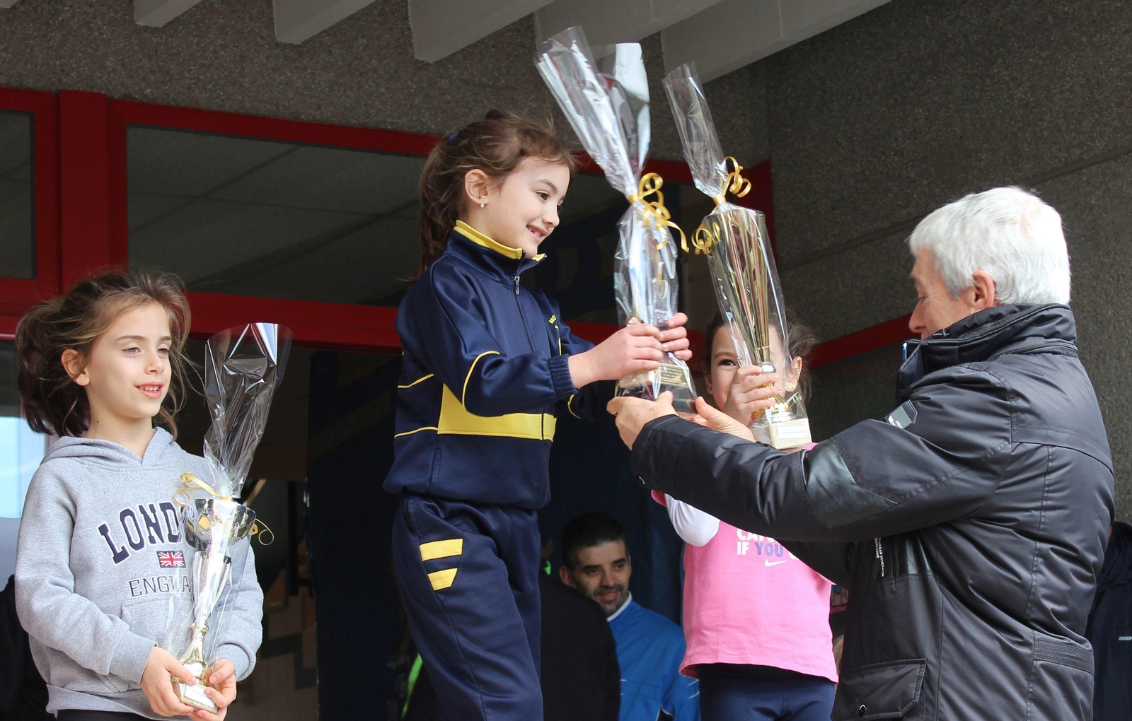 El concejal Manel Fernández hace entrega de uno de los trofeos en el cross escolar de ayer.
