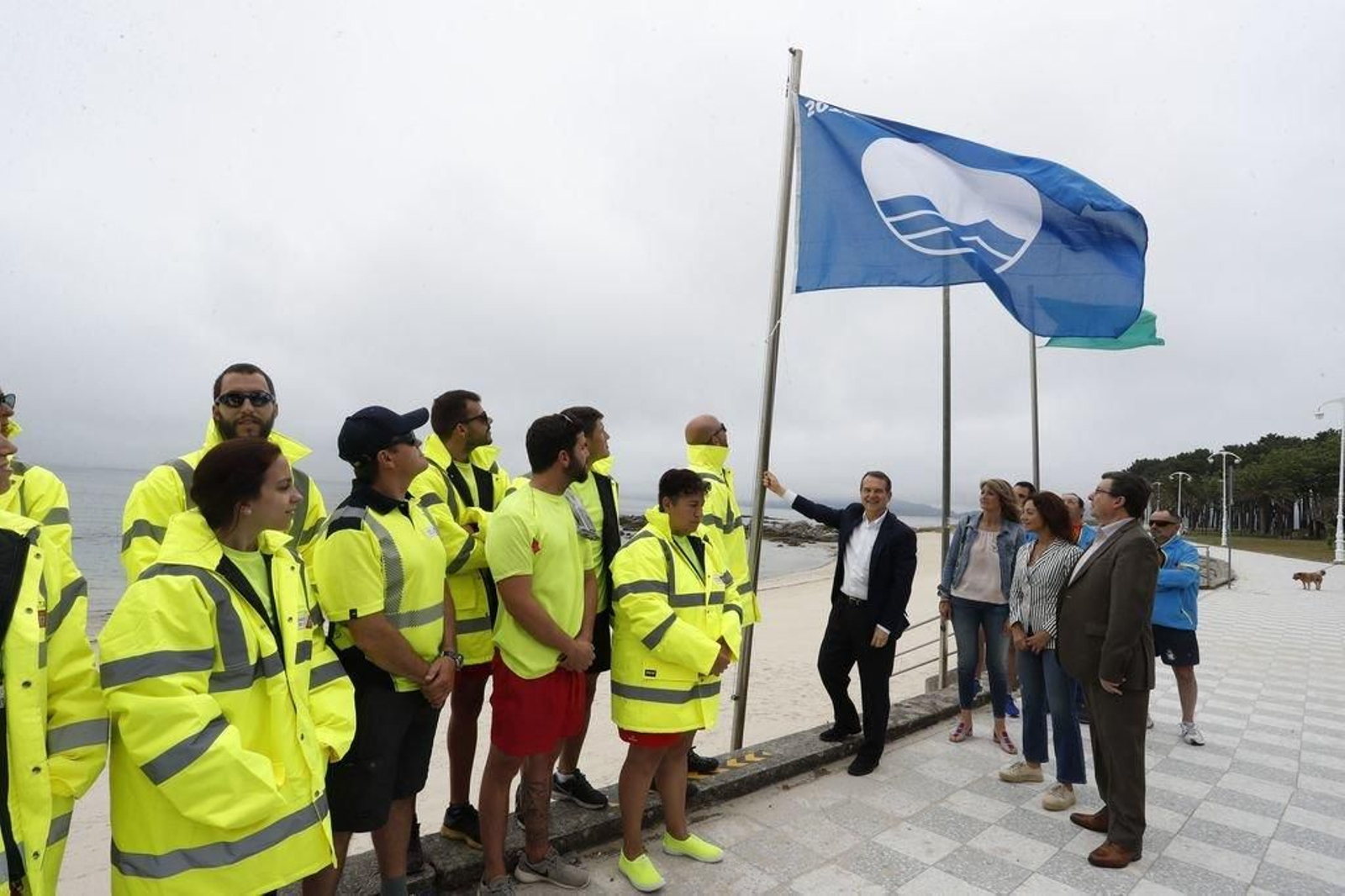 Caballero izando una bandera azul en Samil .