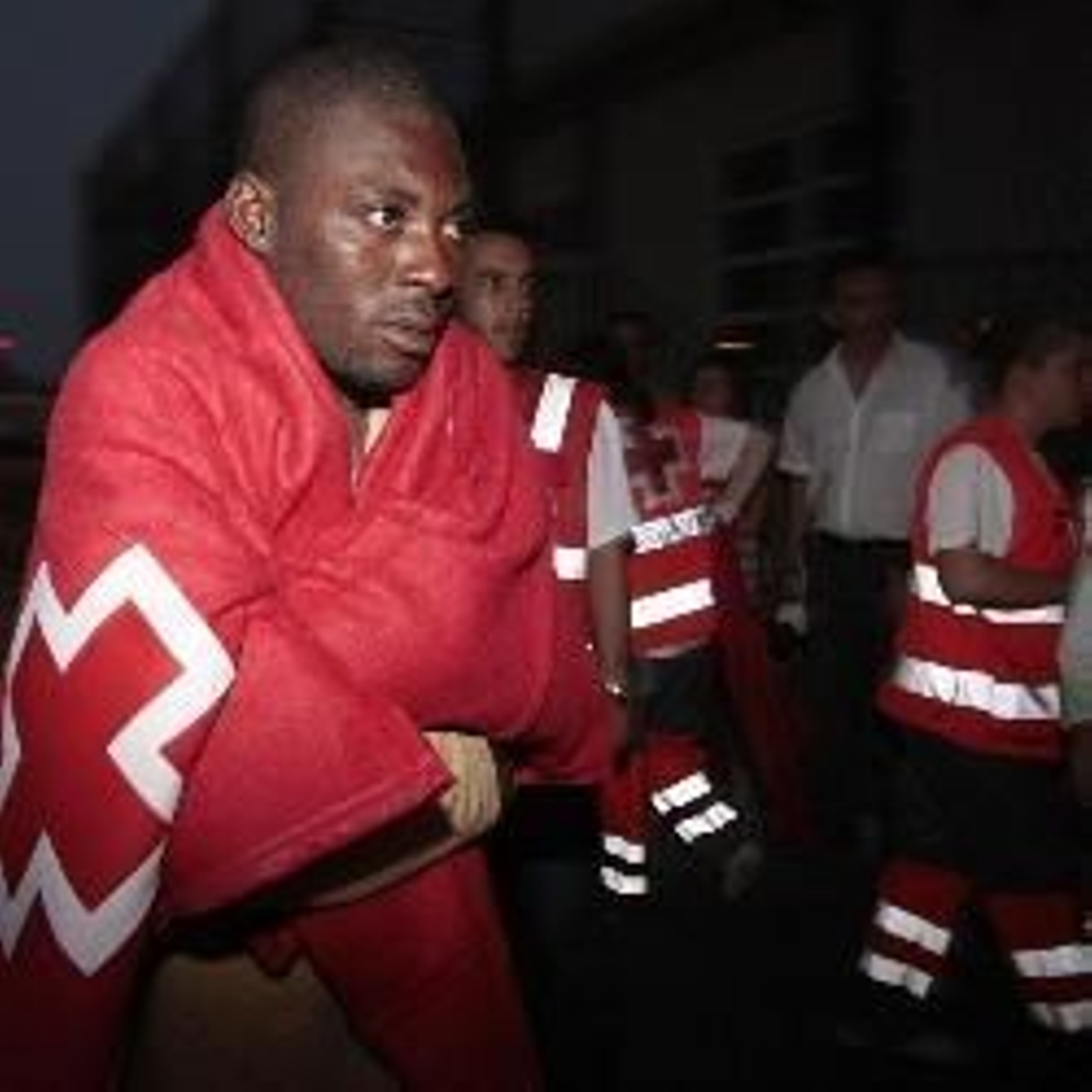 Inmigrantes tapados con mantas proporcionadas por  servicios de la Cruz Roja. (Foto: EFE)