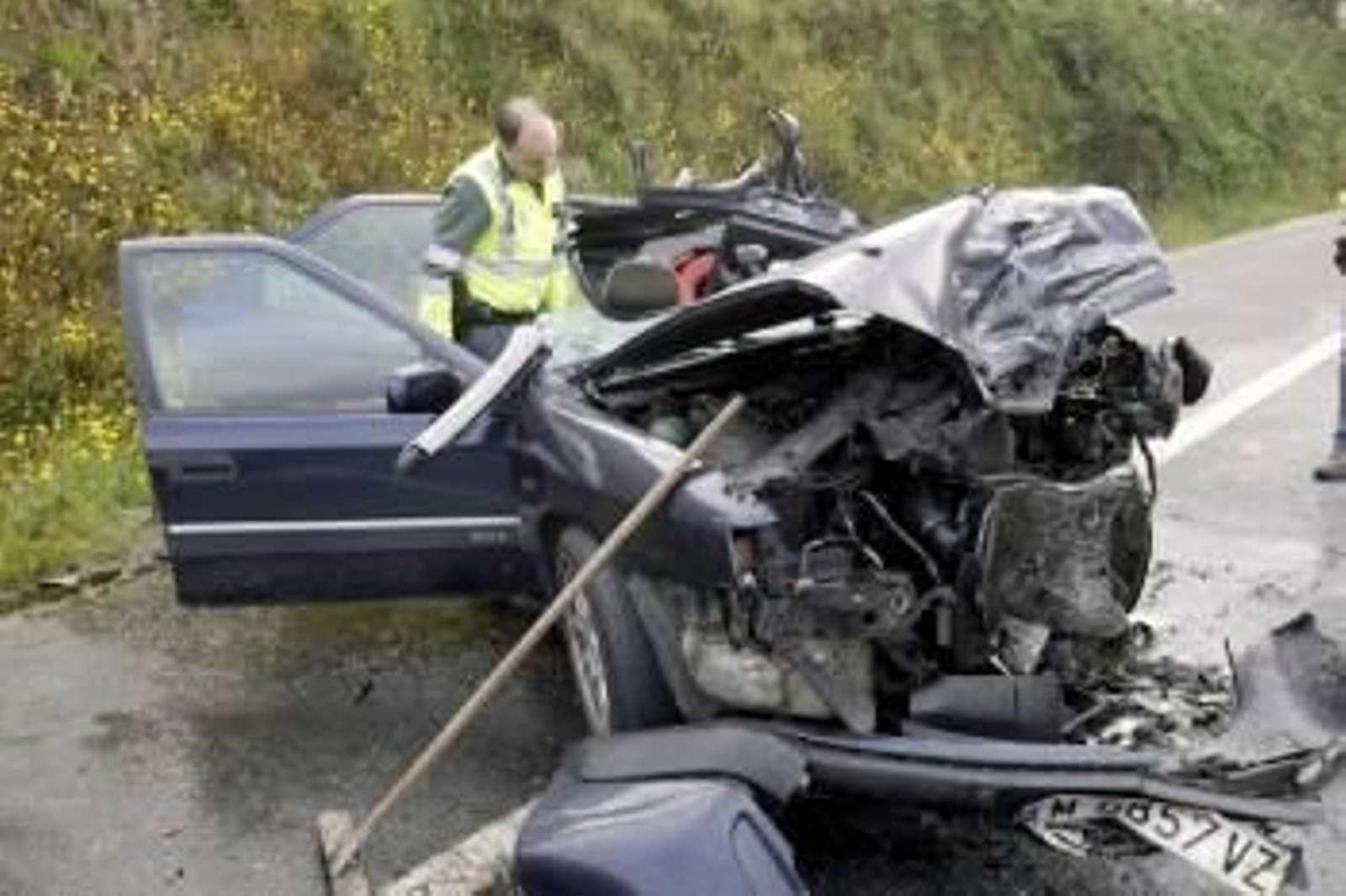 Un agente de Tráfico observa los restos de un vehículo accidentado en Redondela. (Foto: ARCHIVO)
