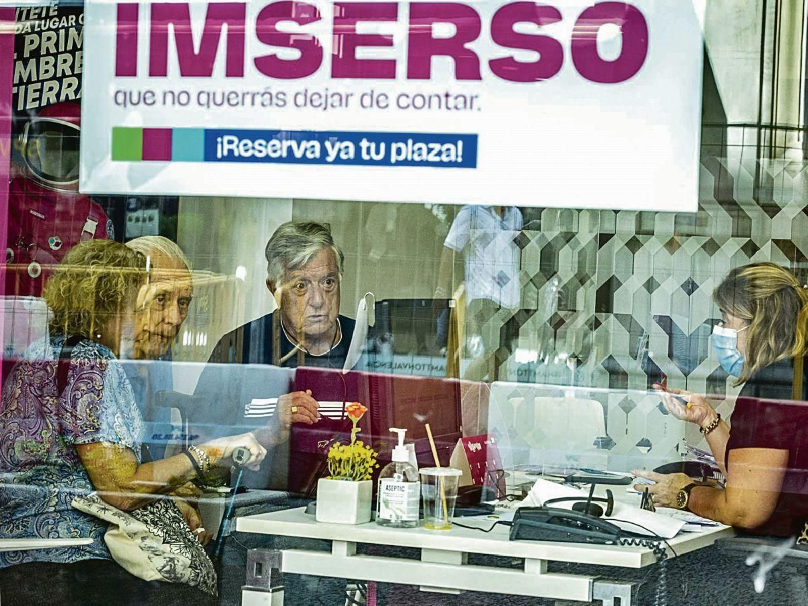 Varias personas mayores se informan en una agencia de viajes adherida al programa del Imserso.
