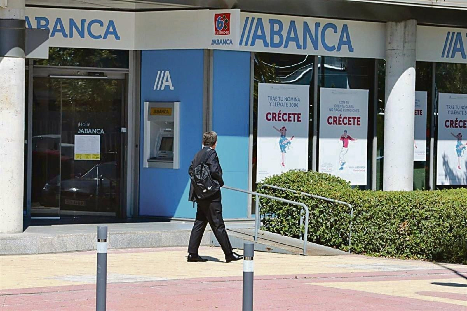 Un hombre pasa junto a una sucursal de Abanca.