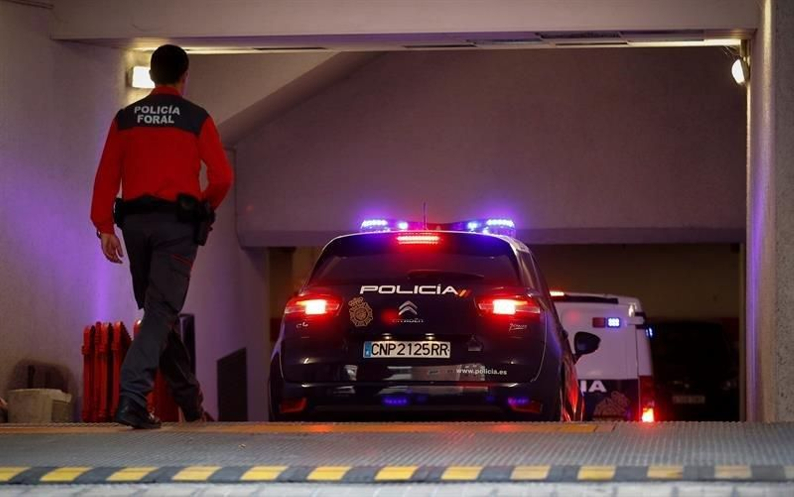 El coche y el furgón de la Policía que conduce a los cinco sevillanos acusados de violar a una joven