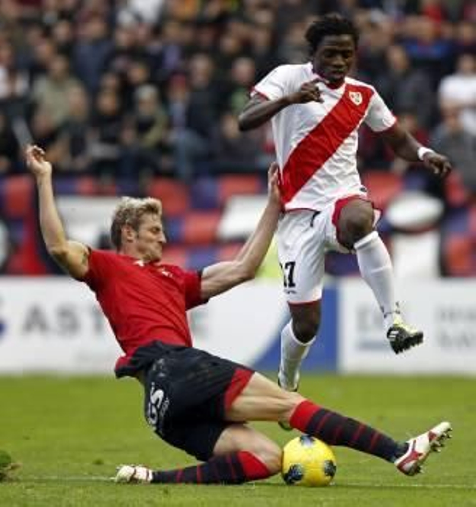 El delantero guineano del Rayo Vallecano, Lass Bangoura (d) pelea un balón con el defensa de Osasuna Rubén González (Foto: EFE)
