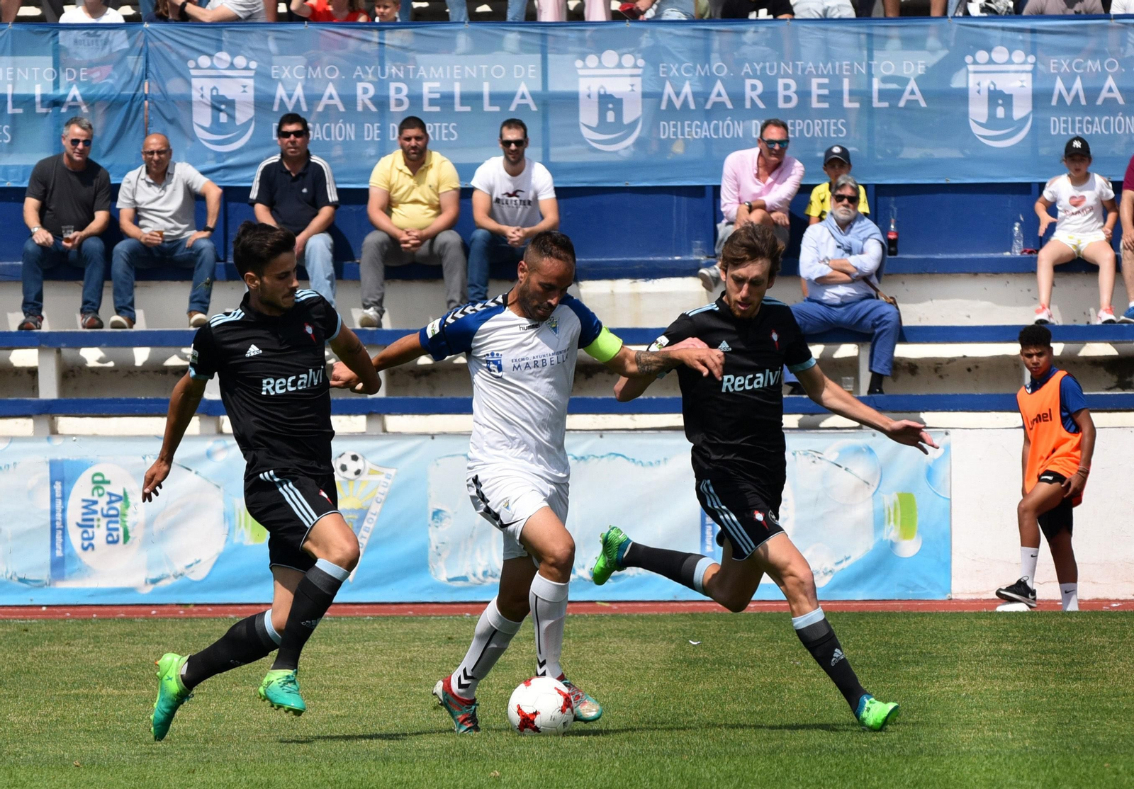 Los mediocentros del Celta B, Rai y Álex Serrano, persiguen al capitán local Añón en el transcurso del encuentro de la mañana de ayer en Marbella.
