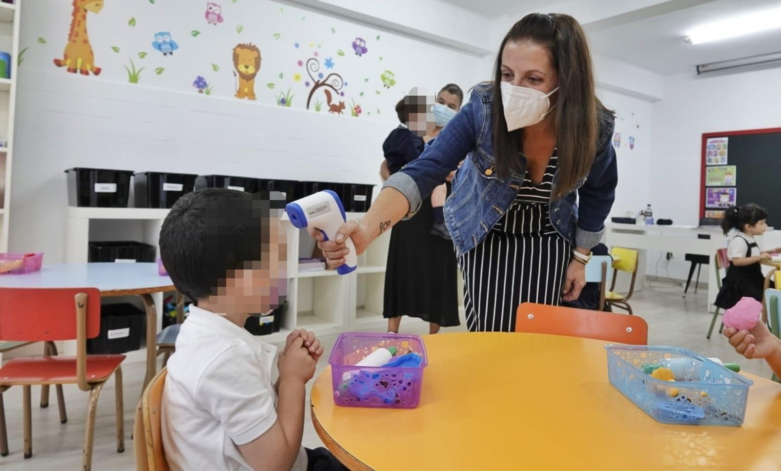 Una profesora toma la temperatura a un alumno de Educación Infantil durante el primer día de clase, ayer, en el Colegio Mercantil de Vigo.