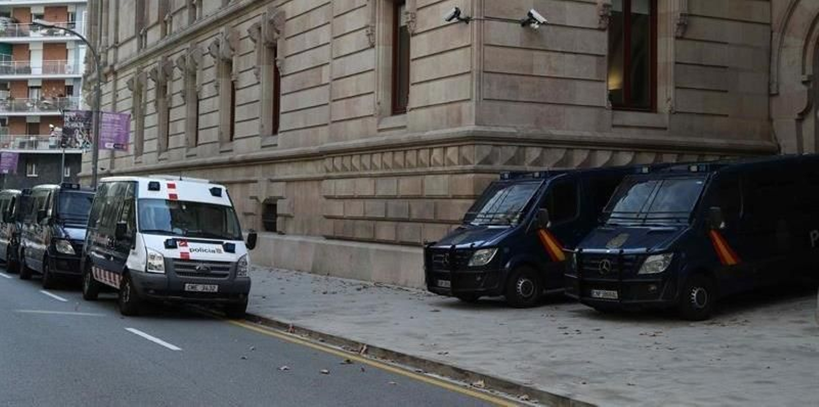 Furgonetas de la Policia Nacional y de los Mossos d'Esquadra ante el edificio de la Audiencia de Barcelona