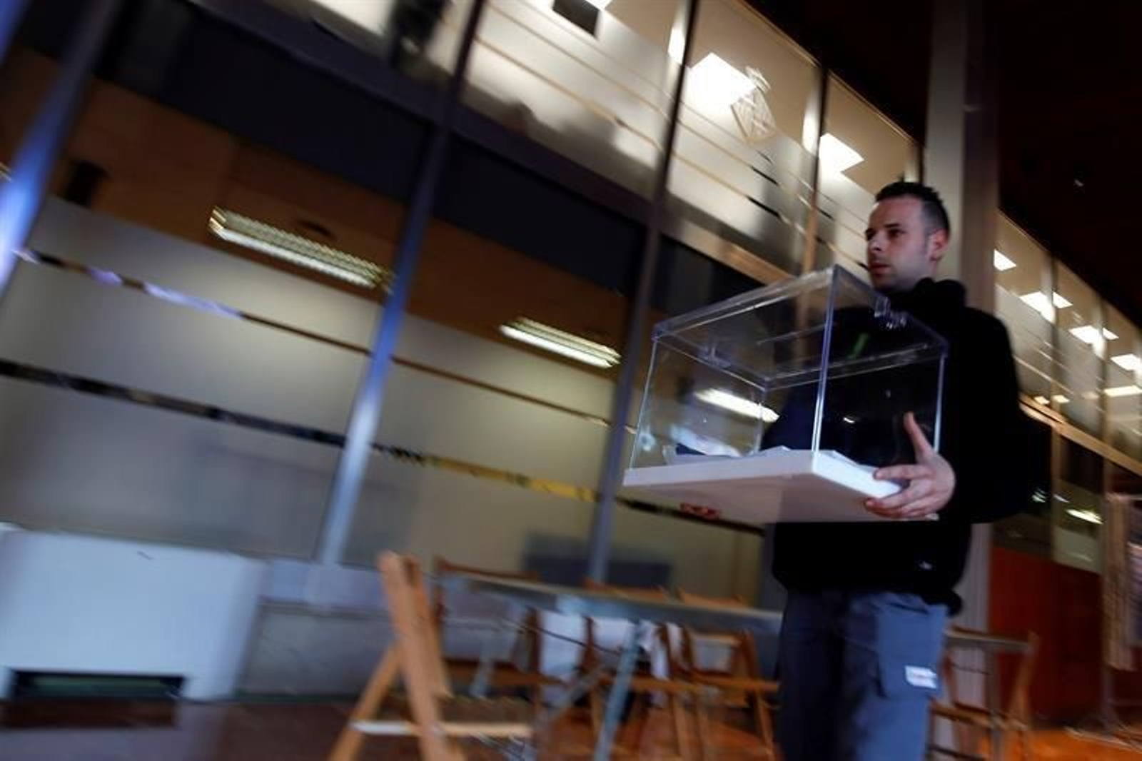 Un operario traslada una urna en el Ayuntamiento de Barcelona, convertido en colegio electoral.