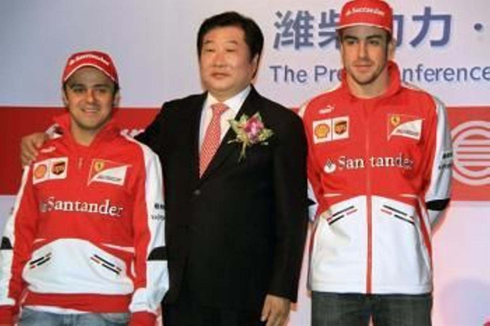 Los pilotos de Ferrar Felipe Massa (i) y Fernando Alonso (d) posan junto a Tan Xuguang, presidente ejecutivo de Weichai Power