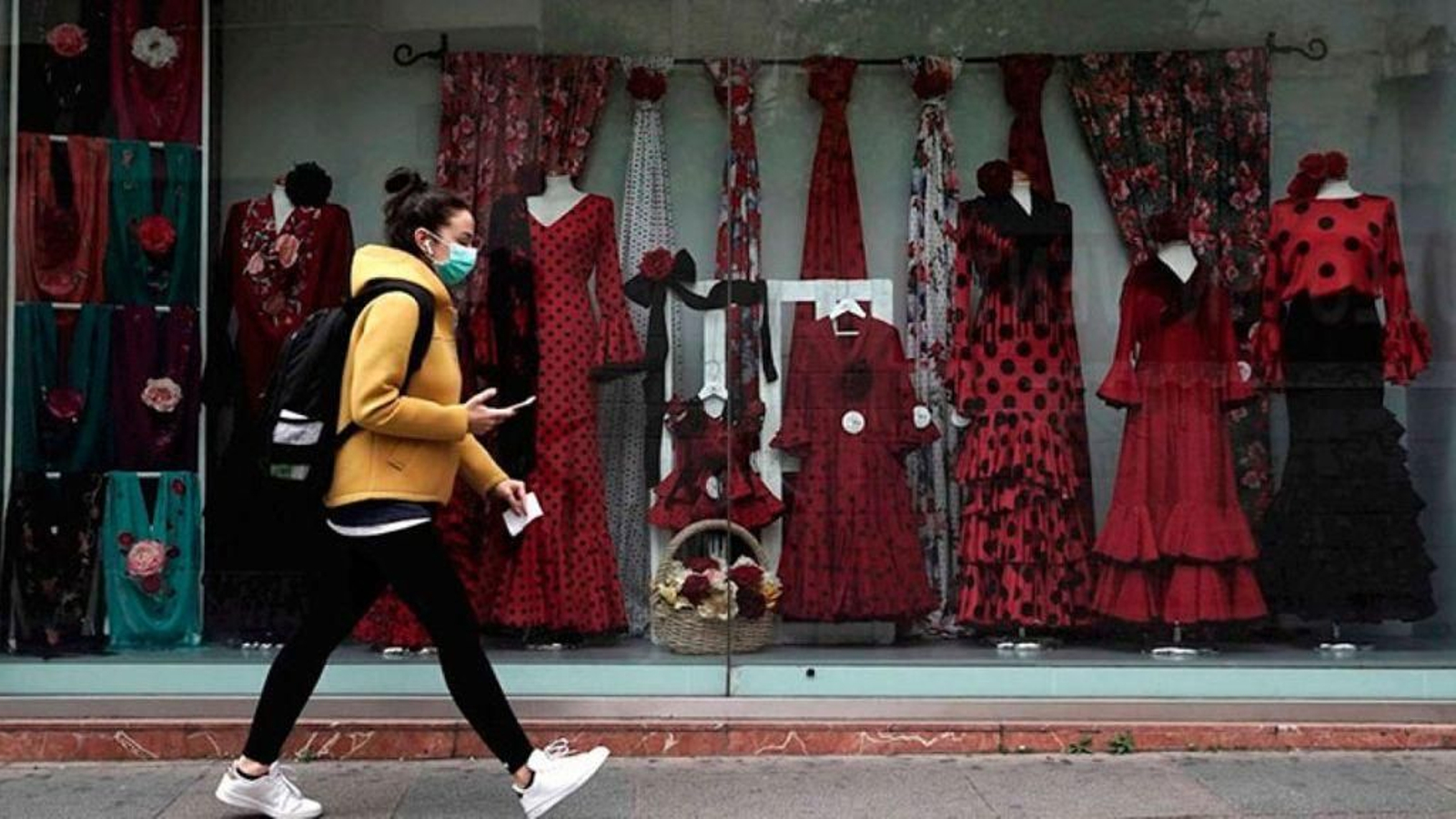 Una joven pasa ante una tienda.