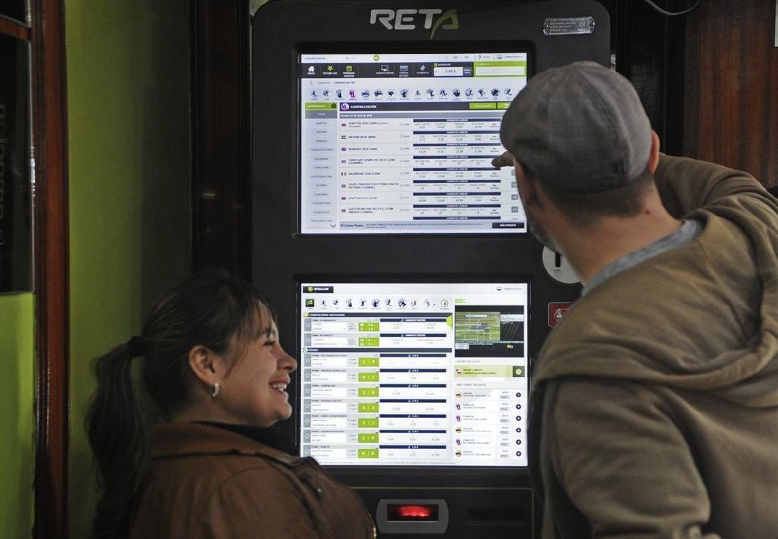 Dos personas, ante una máquina de apuestas en un salón de juego ourensano.