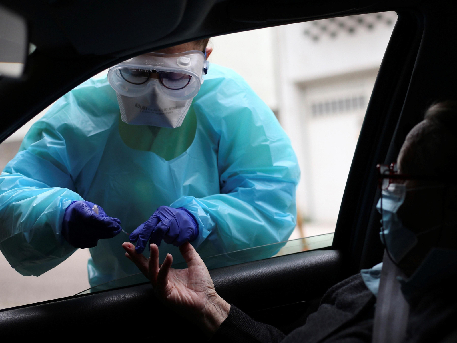 En la imagen, un sanitario toma una muestra de sangre