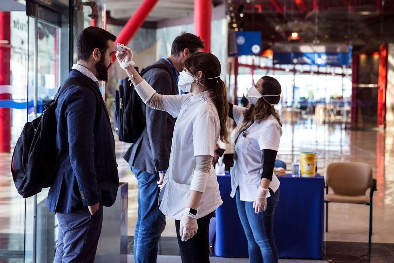 Personal sanitario del "European Robotics Forum" de Málaga toma la temperatura corporal a visitantes.