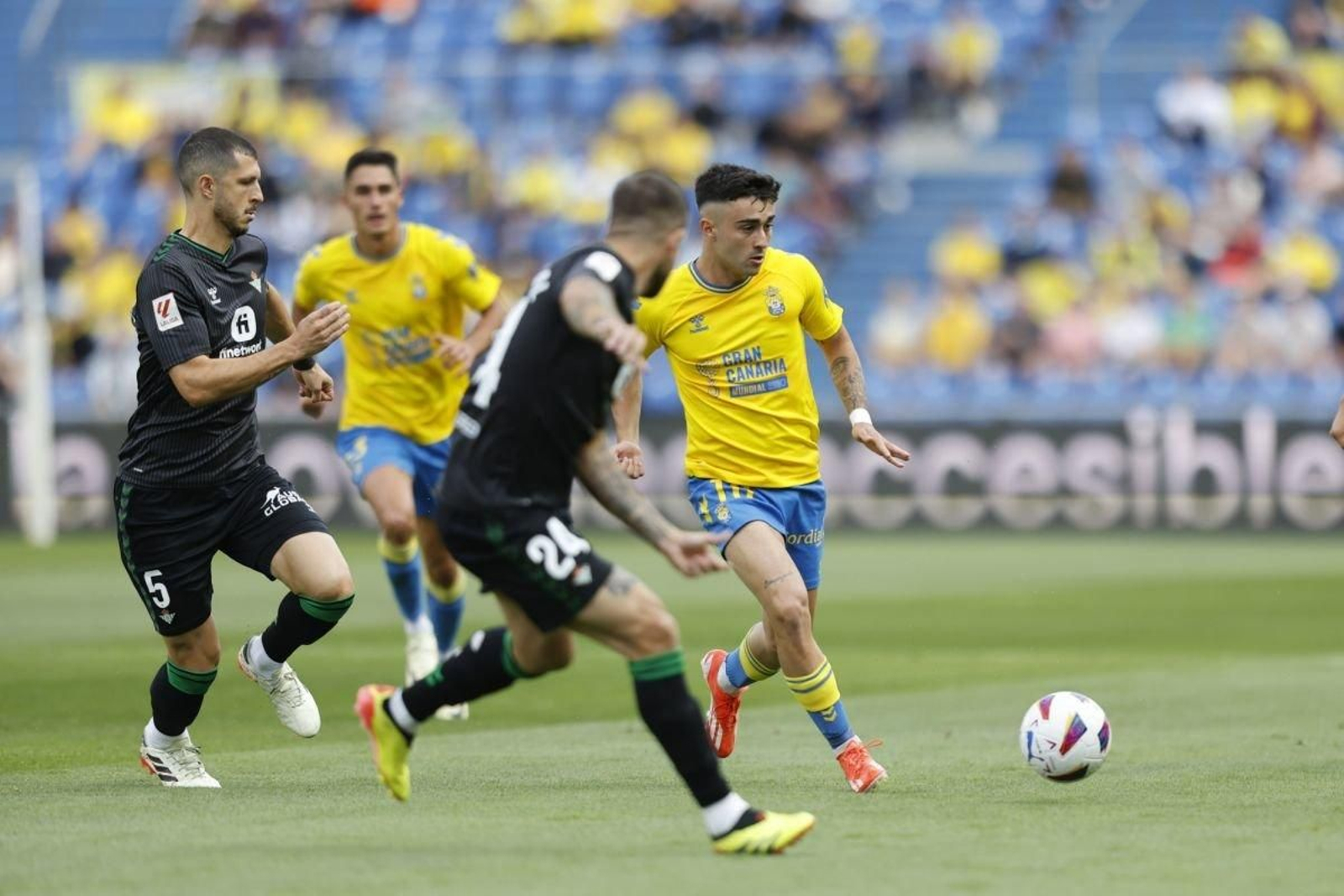 Alberto Moleiro, autor del segundo gol de Las Palmas, remata ante los béticos Guido y Aitor Ruibal.
