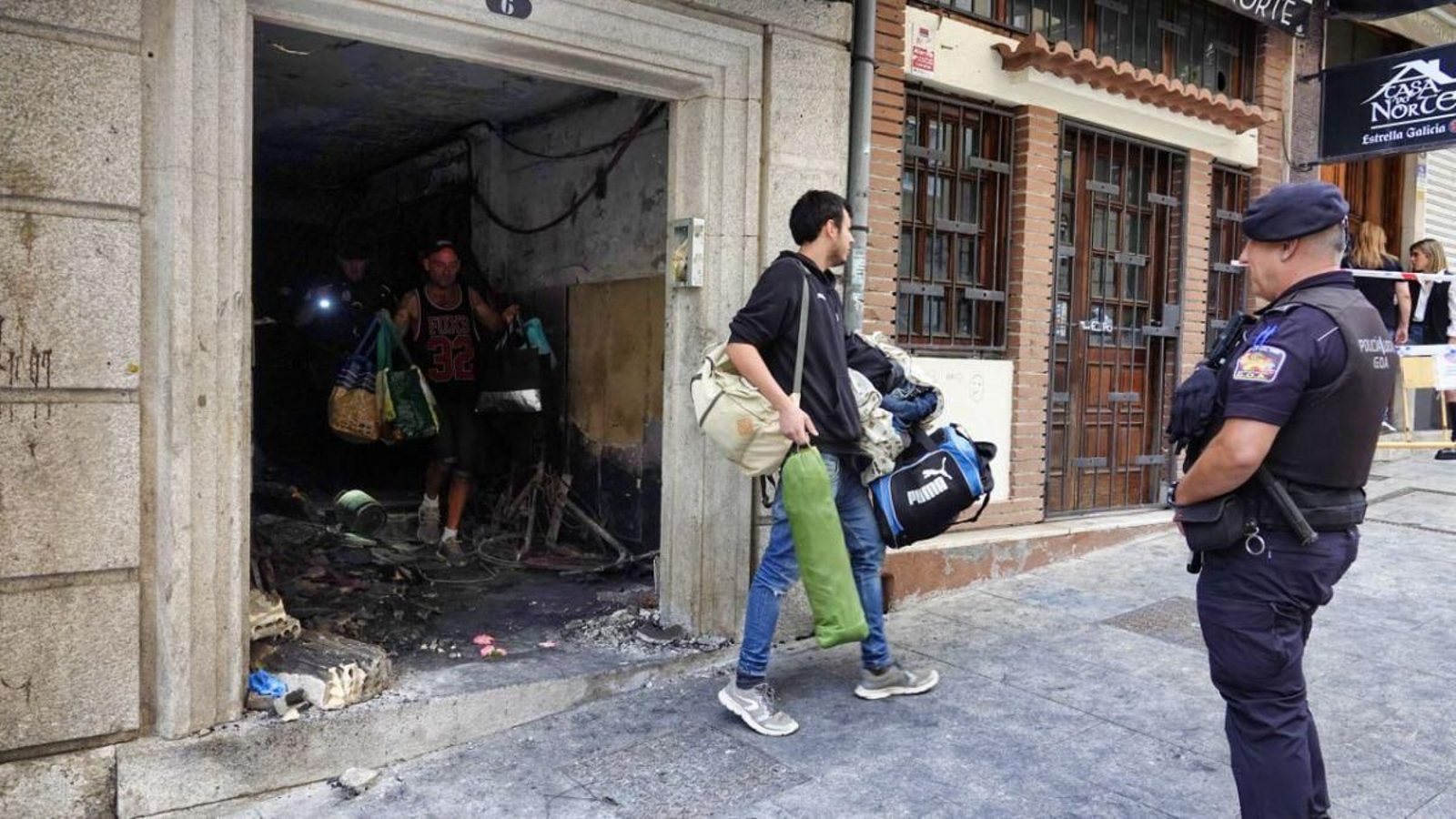 Okupas regresaban ayer por la mañana al edificio (aún precintado) para recoger sus pertenencias, 24 horas después del incendio y tras pasar la noche realojados.