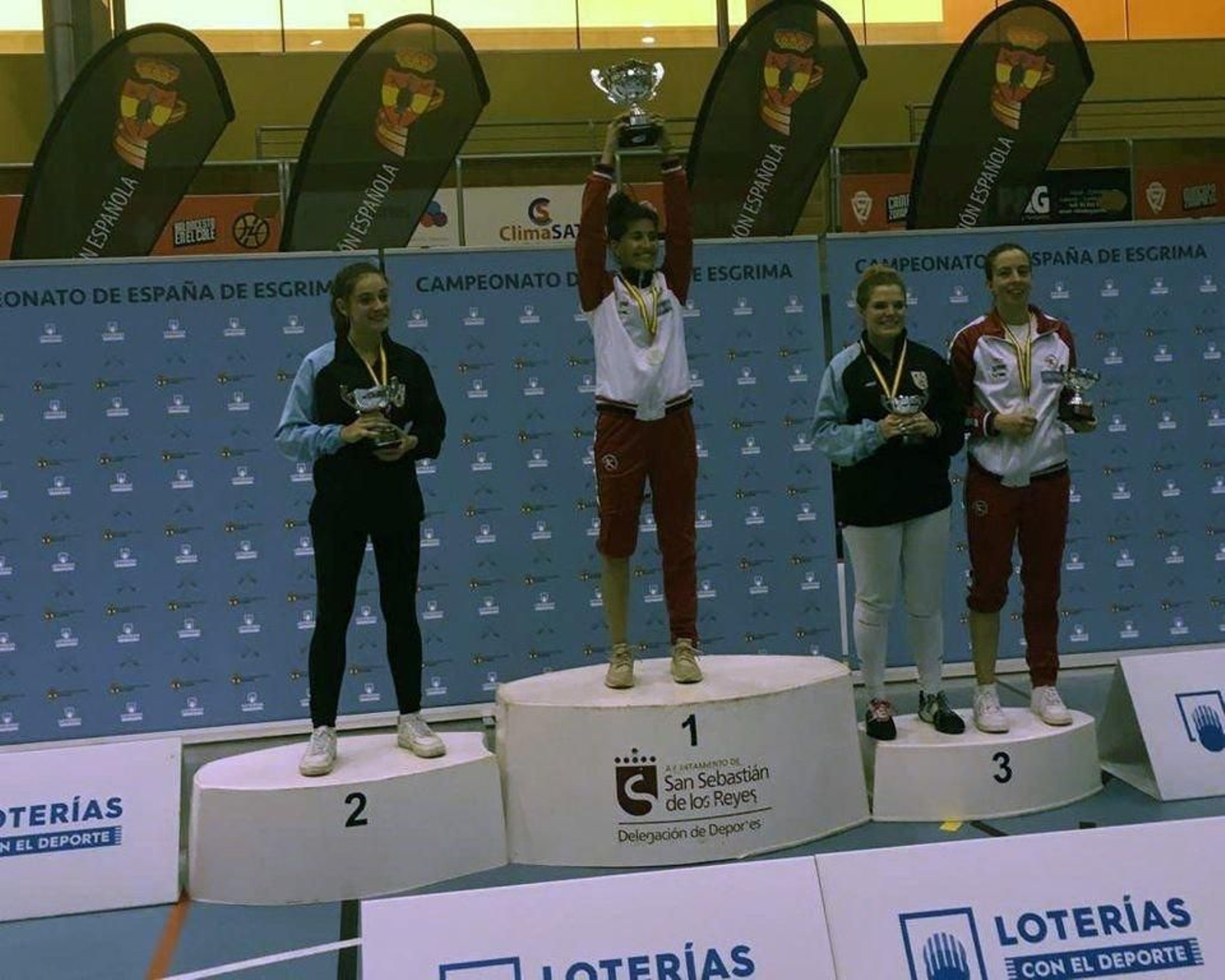 Mariño levanta el trofeo de campeona, con Romero a su izquierda.