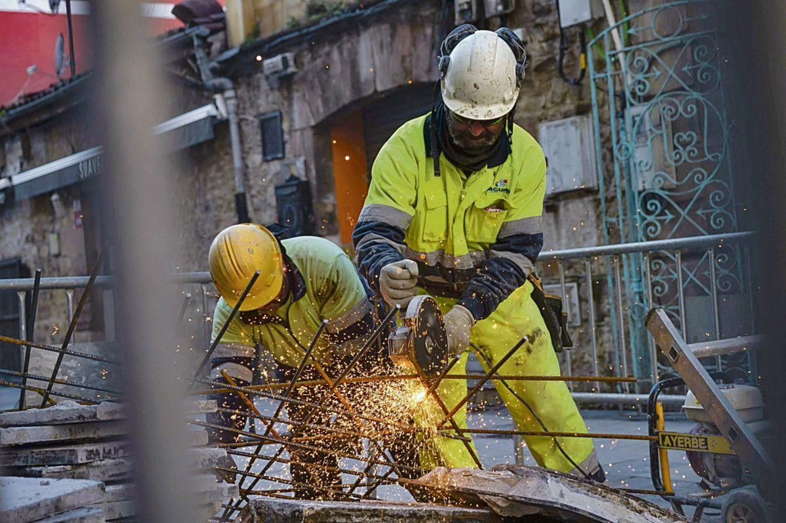 Dos empleados del sector de la construcción trabajando en una obra.